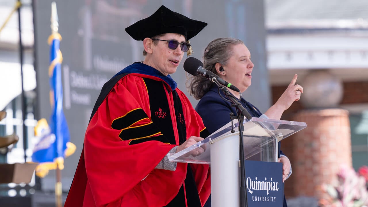 Provost Deb Liebowitz addresses graduates and guests from a podium.